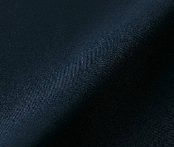 表地には撥水性を持つ高密度なデュスポ生地を使用し、裏地との間に防風性のある特殊フィルムを挟み込んだ3層ラミネート構造の生地